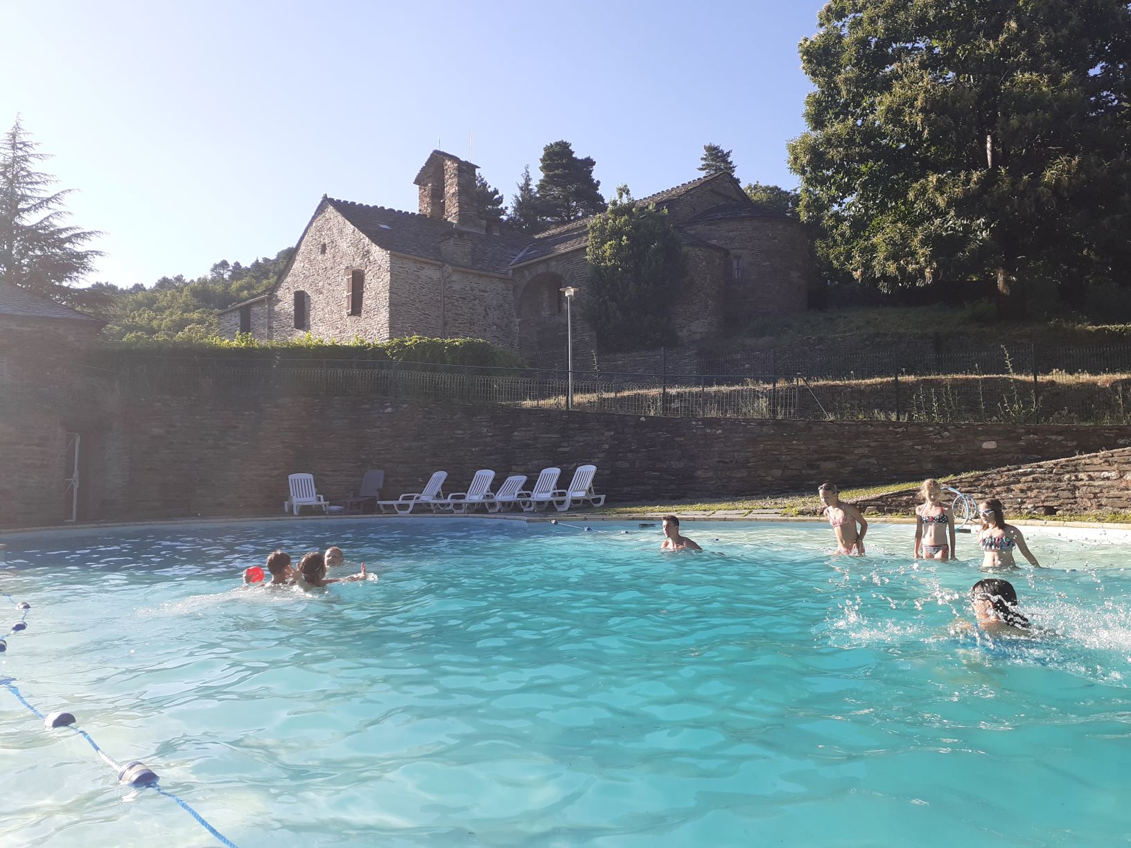 Deux photos : un fruitier en fleur dans le pré du village de vacances les hauts de saint privat et une rivière à la couleur magnifique qui attend vos baignades