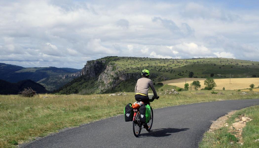 Vélos en Lozère Un cycliste sur une petite route tout en haut du Causse Méjean.